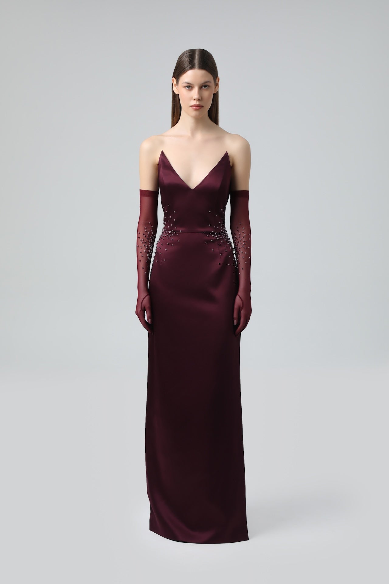 Full view of model wearing burgundy crystal-embellished mesh gloves paired with evening dress.