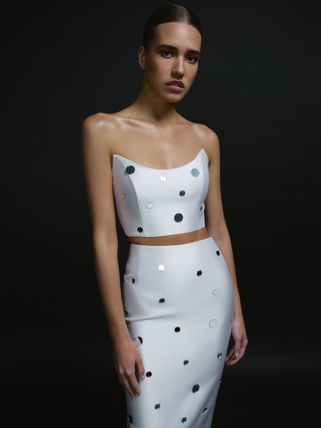 Close-up of white mirror embellished bridal crop top with sculpted neckline.